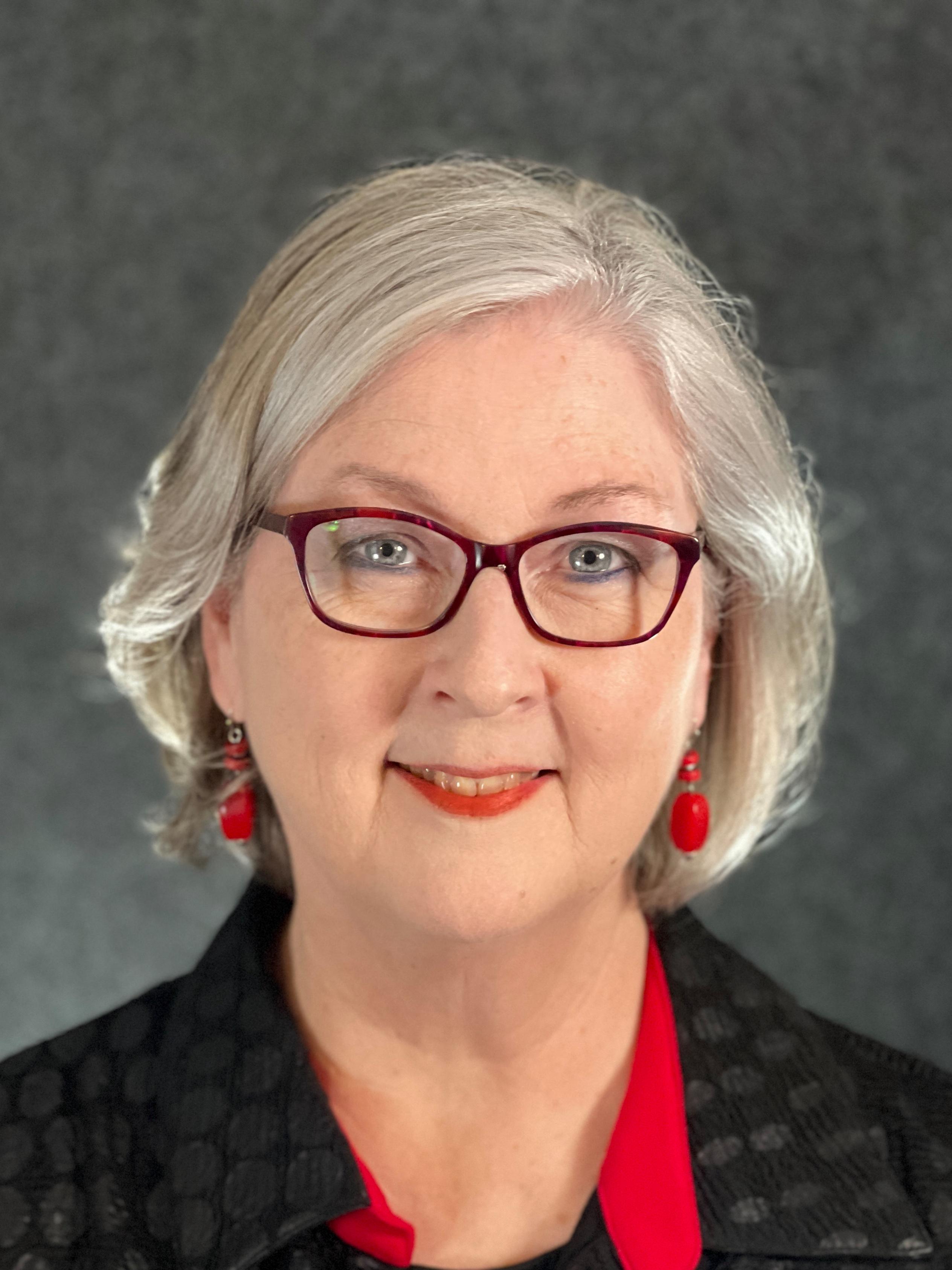 Woman, silver hair, glasses, black and red attire